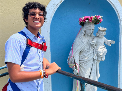 A young boy by the crowned statue of Mary Help of Christians 