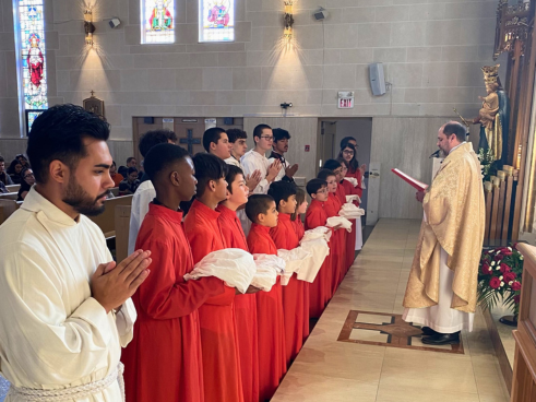 Etobicoke: Fr. Sean McEwen, SDB (right) commissions the alta﻿r servers. 