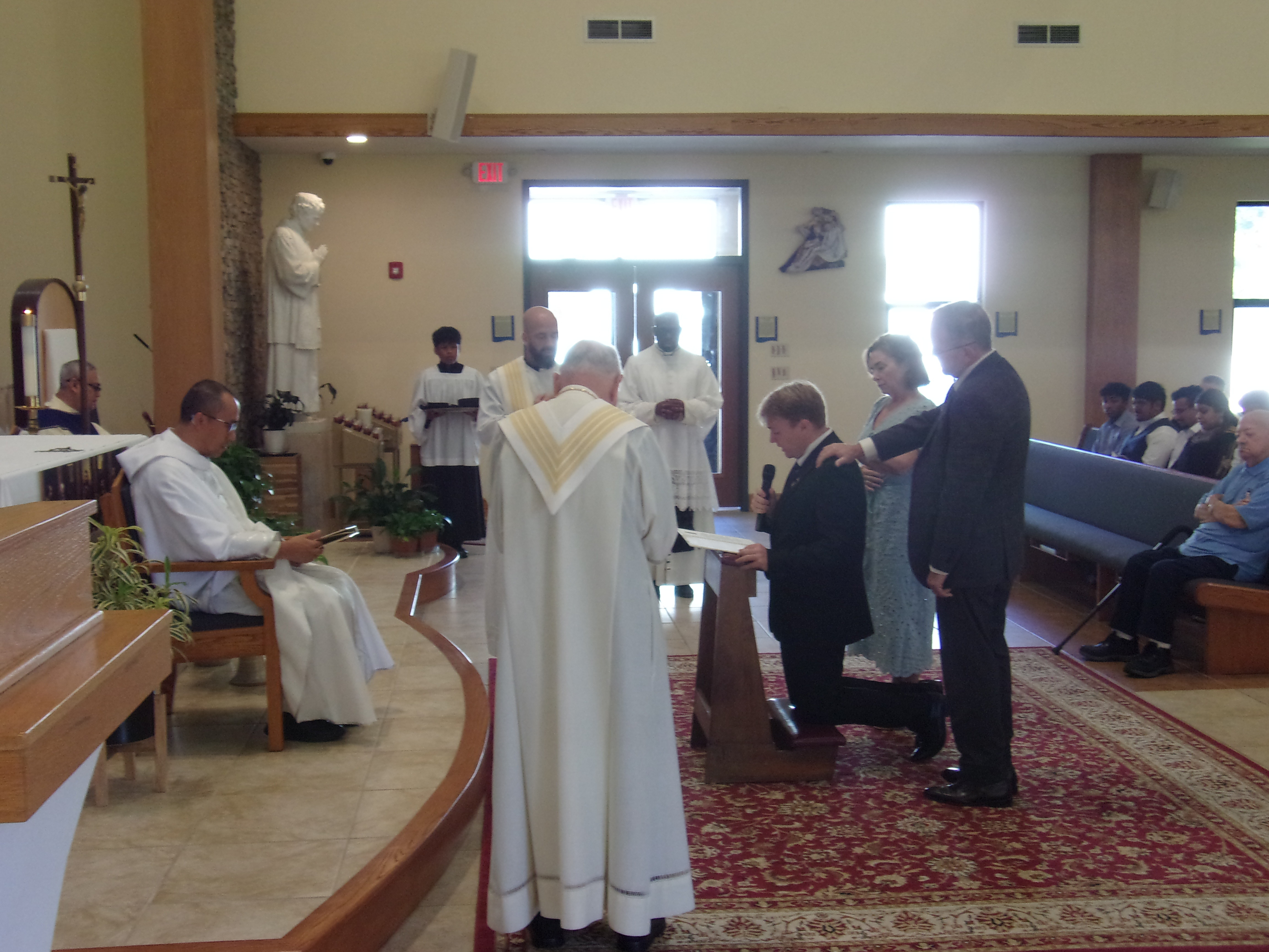 Bro. Timothy Hughes, supported by his parents Regina and Patrick, makes his first profession before Fr. Dominic Tran, witnessed by Frs. Steven DeMaio and Patrick Angelucci. 