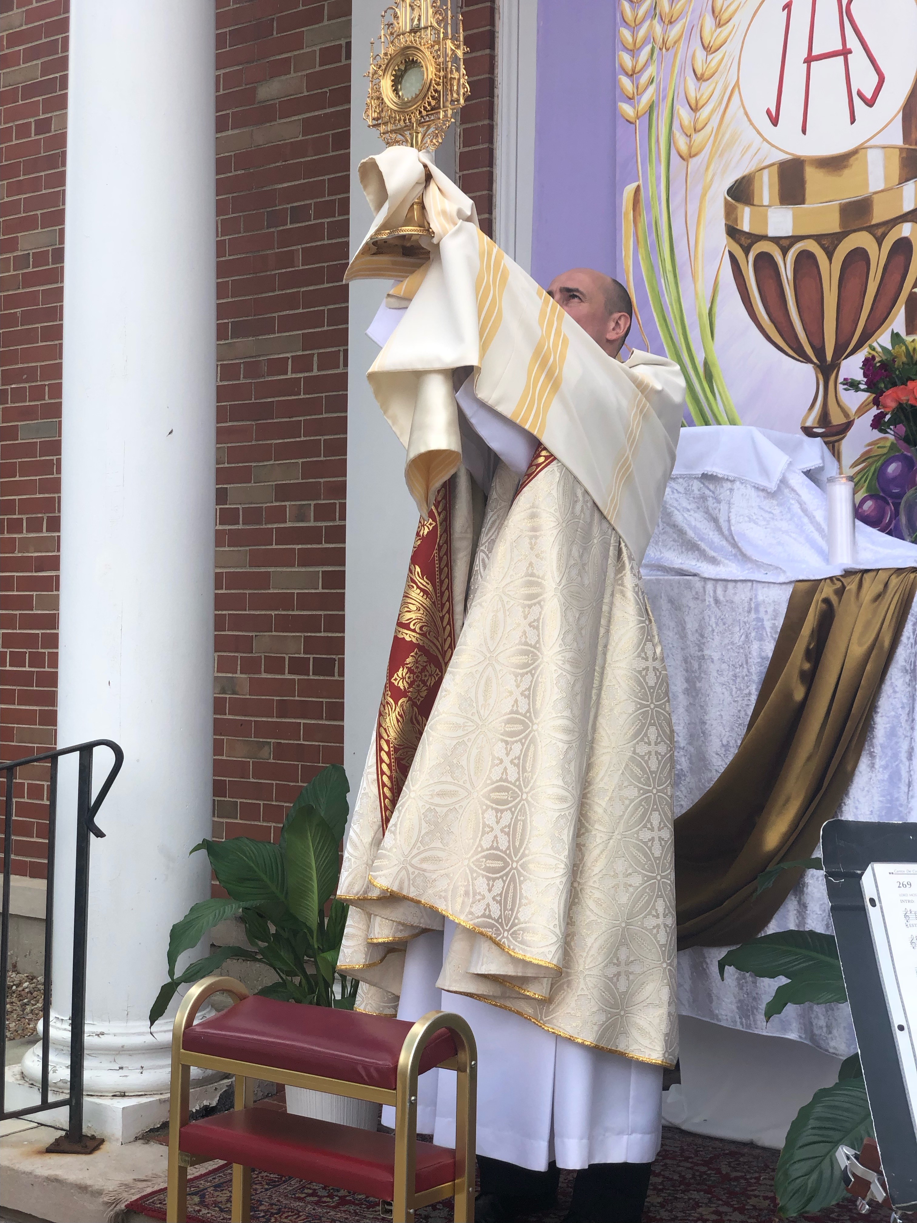 Fr. Kris Cepil, SDB, holds the monstrance during the celebration in Chicago.