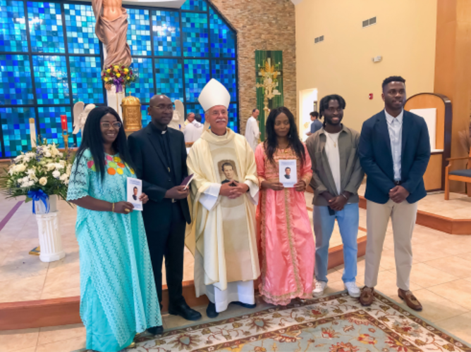 Br. Pascal Mukuye, SDB (second from left), with his family and Bishop Taylor (center) after he made his first profession as a Salesian of Don Bosco
