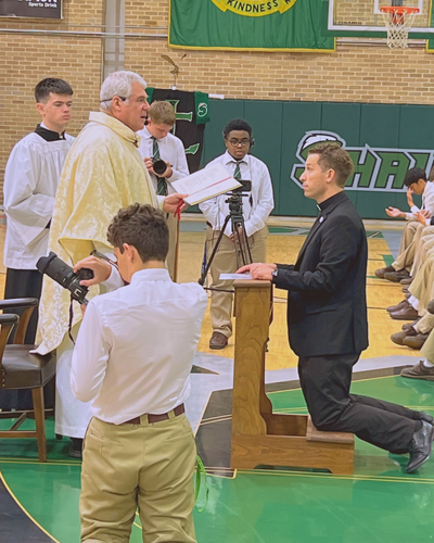 ro. John Taylor renews his profession before Fr. Steven Ryan.