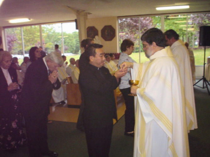 Fr. Jim Cerbone, SDB, gives communion during  the province’s Jubilee Mass in 2005.