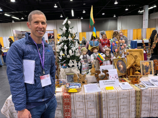 Novice John Taylor at a table for the Lithuanian community