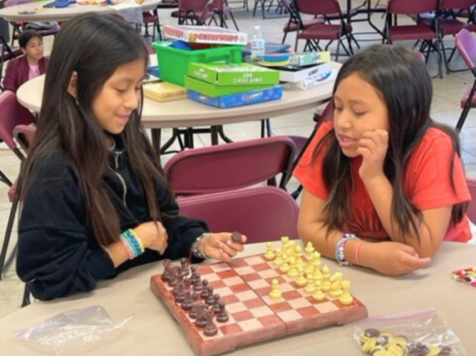 Two campers play chess at Don Bosco Camp in the Valley