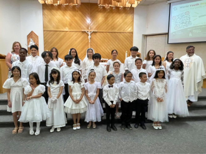 Edmonton: Fr. Raja (right) with young people after they received their First Holy Communion