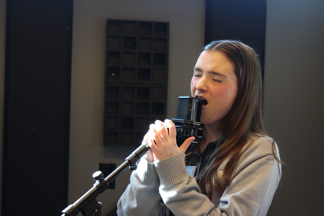 Marrero, AOL: Rebecca Wren ’26 hits a new high note while recording her vocals on the microphone.