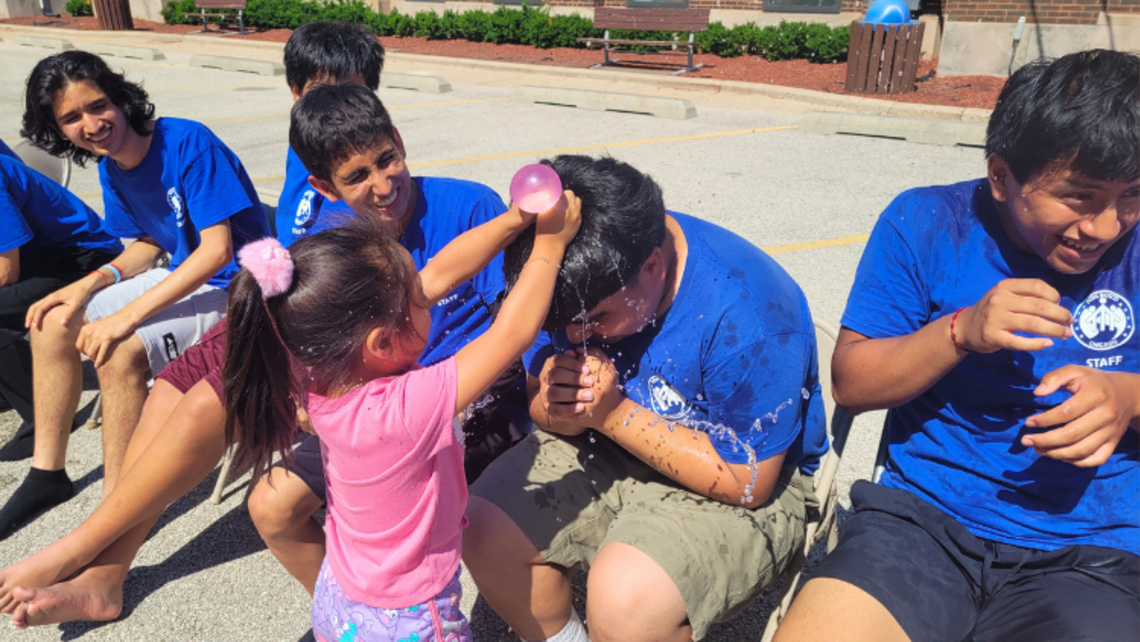 A camper pours a water balloon out on a staff member during a fun day out. | Credit: Fr. Paul Chu, SDB, and Camp Don Bosco Staff Chicago Camp Don Bosco 2026 1