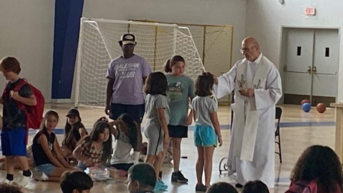 Fr. Bill Buccifierro, SDB Director of Religious Activities, administers Communion and Blessings | Photo by Anita Belmonte East Boston Mass at Summer Camp