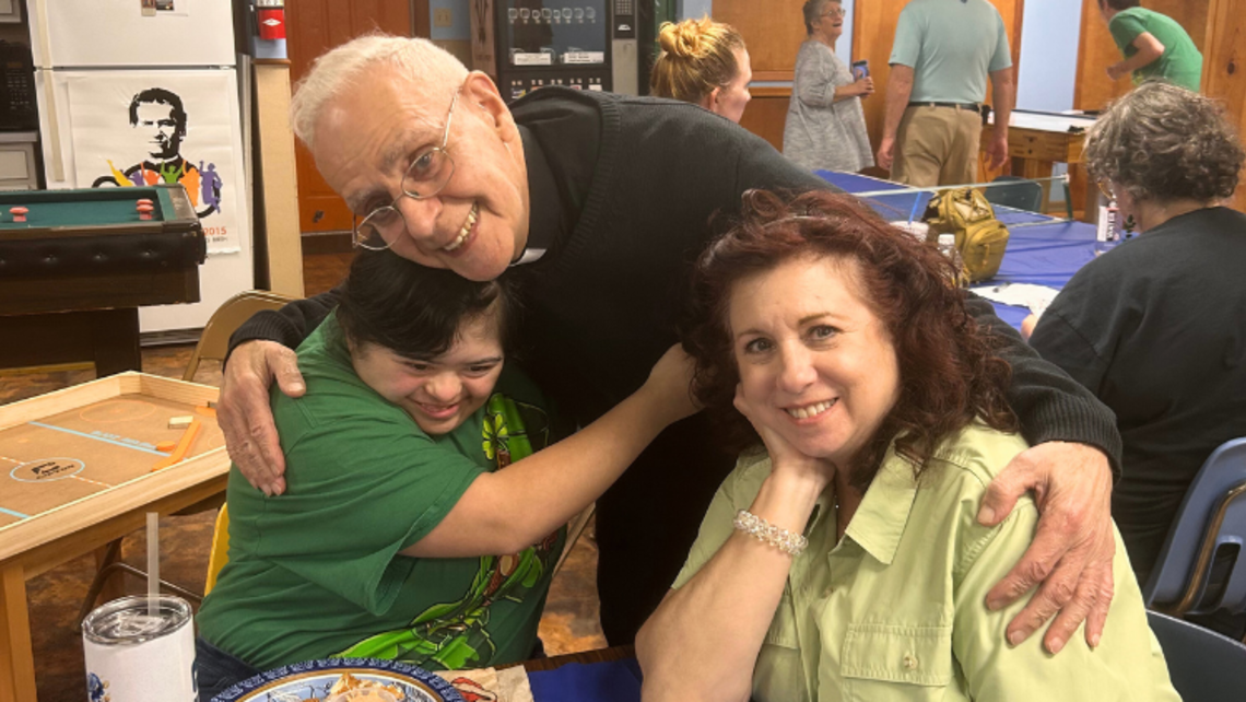 Fr. George Hanna embraces two of Mary Help of Christians' parishioners. | Credit: Fr. Mark Hyde, SDB Harvey Extraordinary People Web