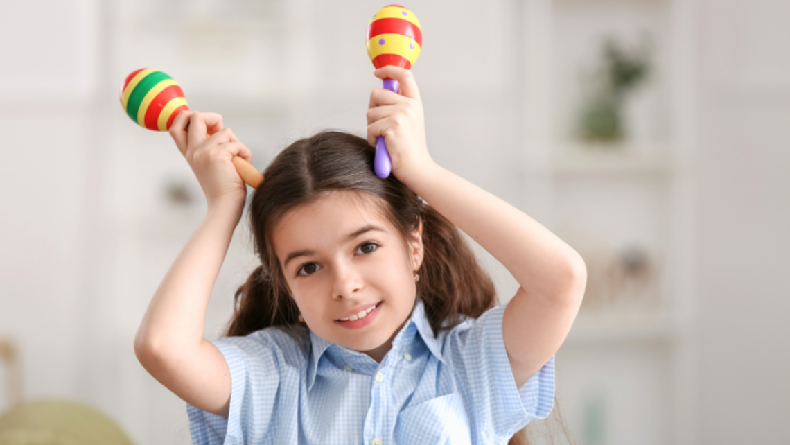 Young girl holds maracas | Courtesy of pixelshot Latin Night 2024