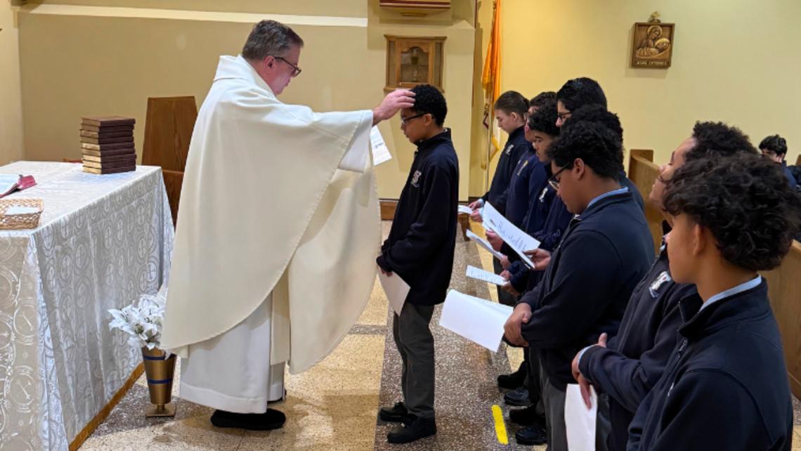 Fr. Richard Alejunas, SDB, prays with Salesian High freshmen. | Credit: Randy Taveras, Marketing Coordinator/Business Teacher, Salesian High School Salesian High Celebrates 150th Anniversary of First Missions
