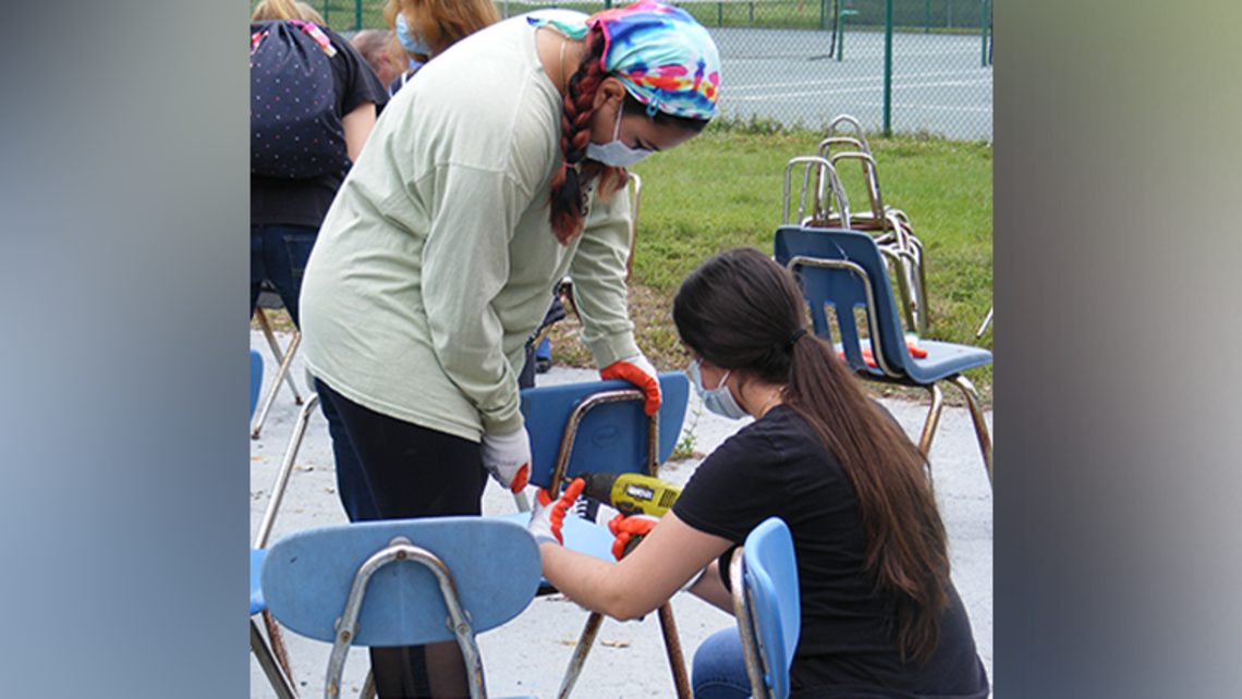 Young volunteers dismantle old chairs for their scrap metal frames | Photo credit: Lili DeGrasse Tampa Honoring Our Blessed Mother