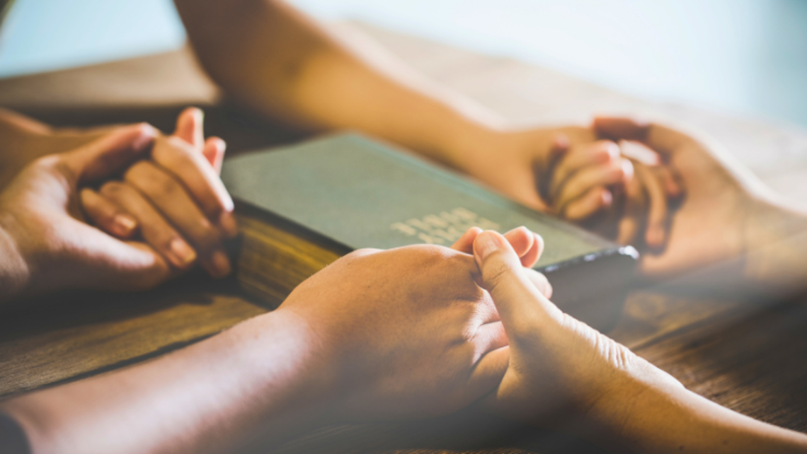 People hold hands in prayer | Photo ©: Canva Pro Weekly Prayer: May 15-21, 2025