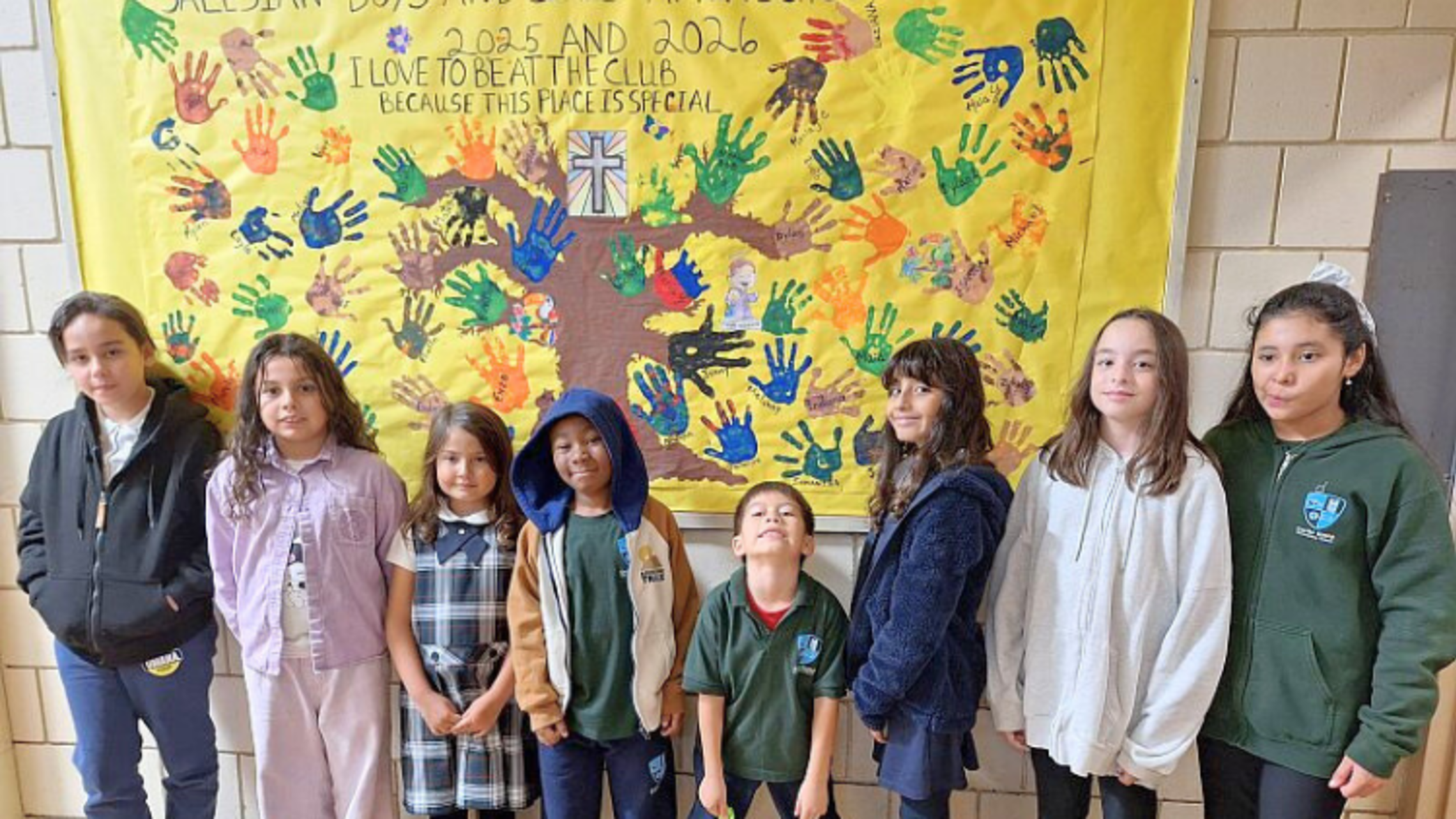 Club members pose with one of the bulletin boards. | Credit: Bro. Bob Metell, SDB East Boston: October 2025 News