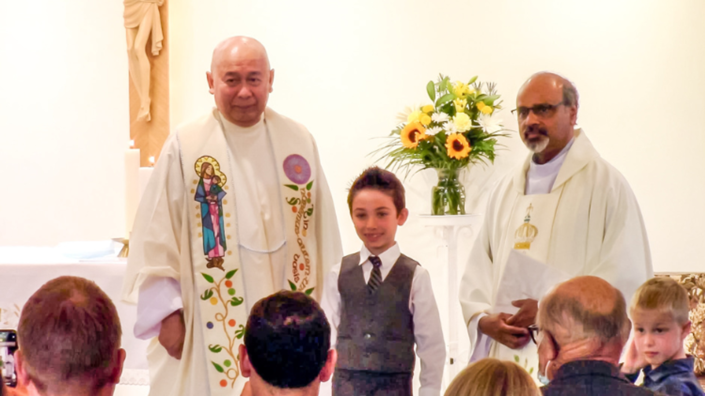 (from left to right) Edmonton Director Fr. Mario Villaraza, SDB; a First Communicant; and Fr. Sagayaraj Devadoss, SDB | Photo by Gerry Simard Edmonton Salesian Feasts