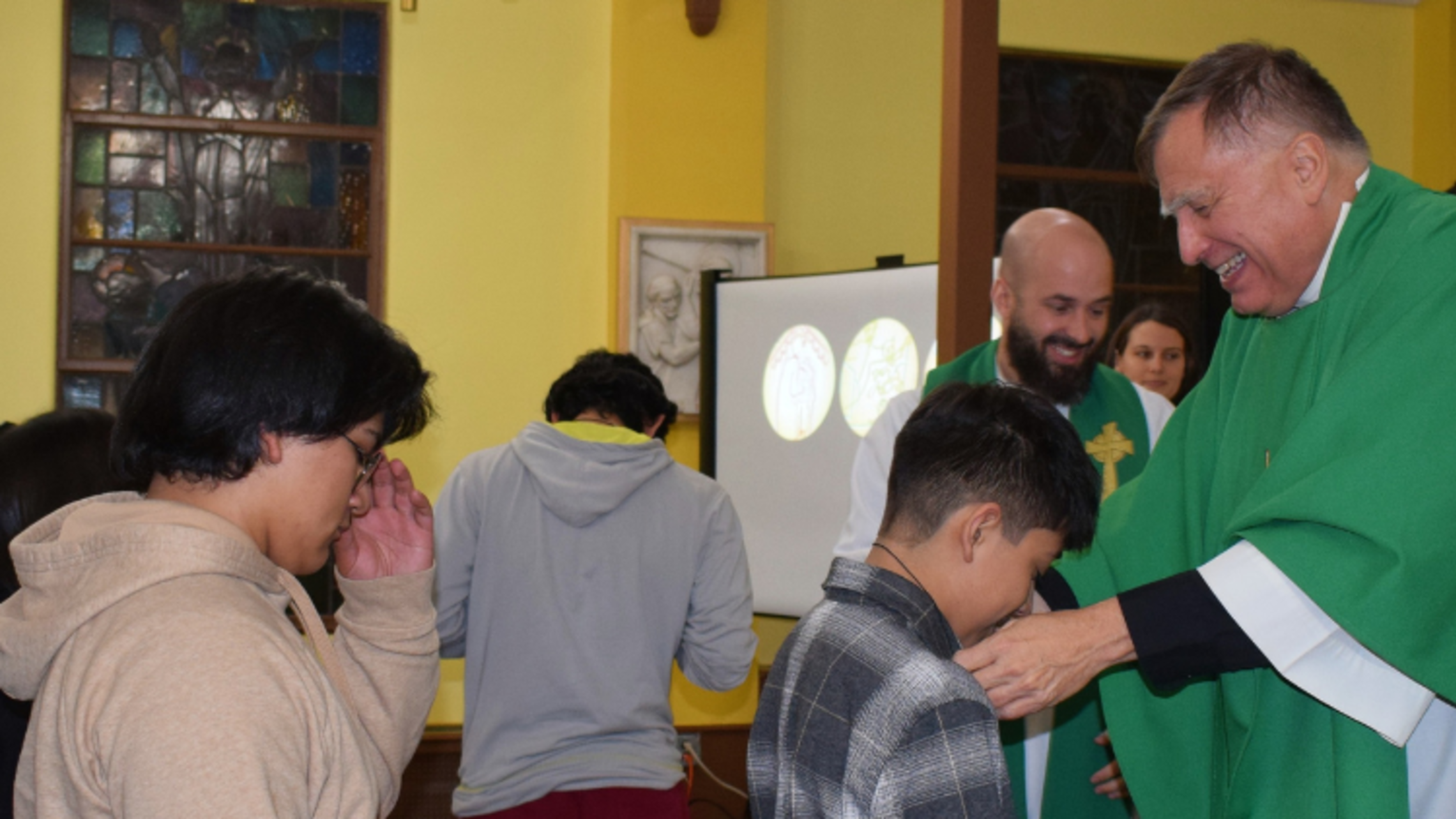 Fr. Lou Molinelli, SDB (right), presents medals at the January Retreat | Photo by Salesian Youth Ministry SYM Corner 02.15.23