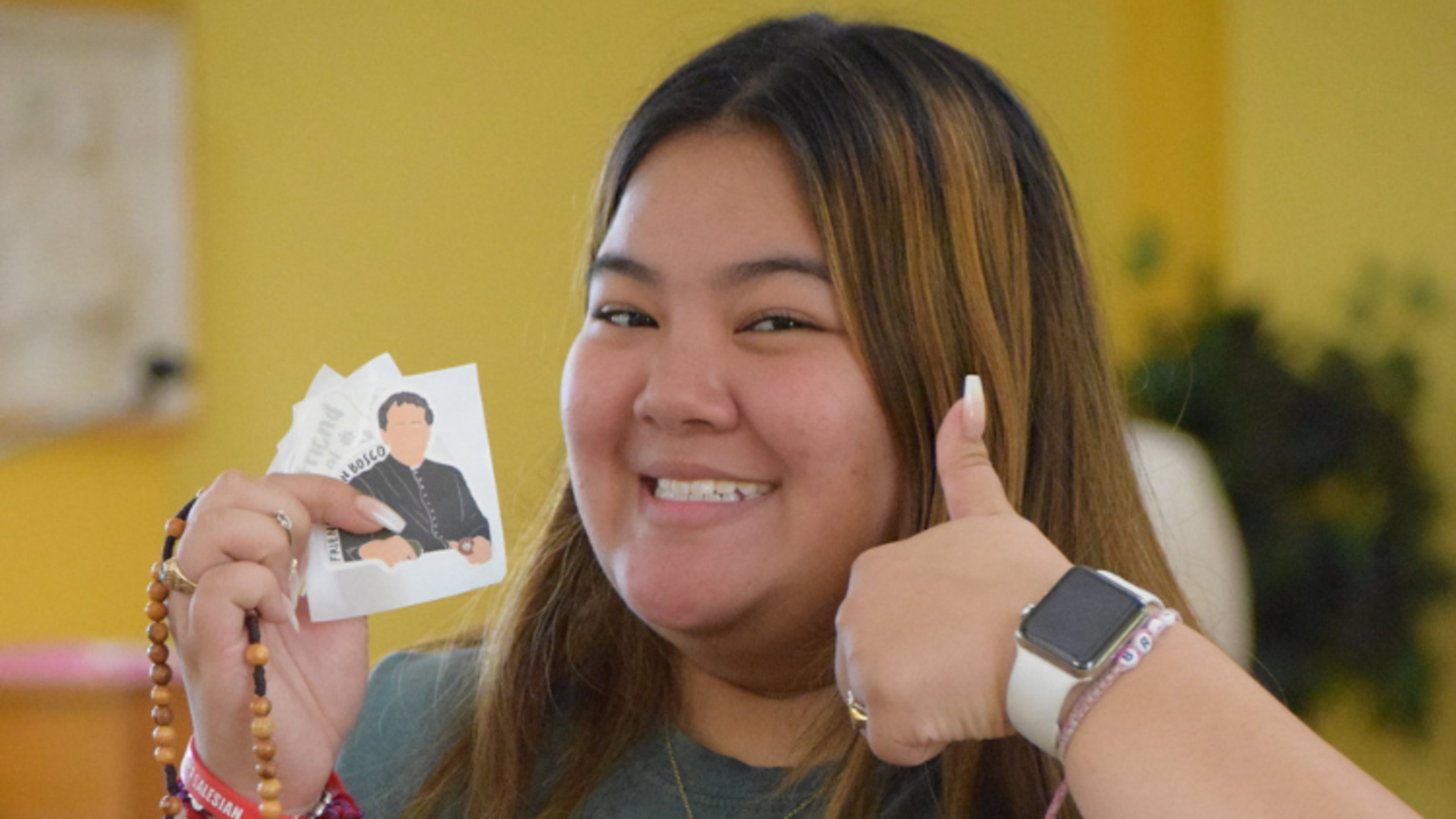 Academy of Our Lady alumna Britney Bui smiles and models the latest Salesian merchandise | Photo by Salesian Youth Ministry SYM Corner 06.29.22
