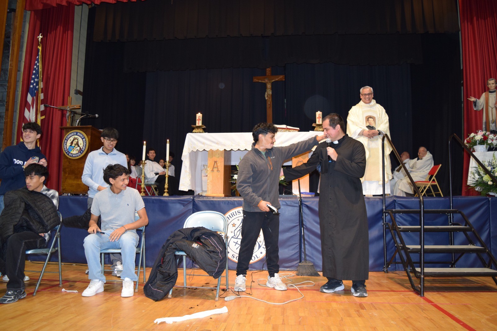 Port Chester: Fr. Franco Pinto and Port Chester youths beam after Fr. Eddie and the kids put on the haircutting skit to honor Don Bosco.
